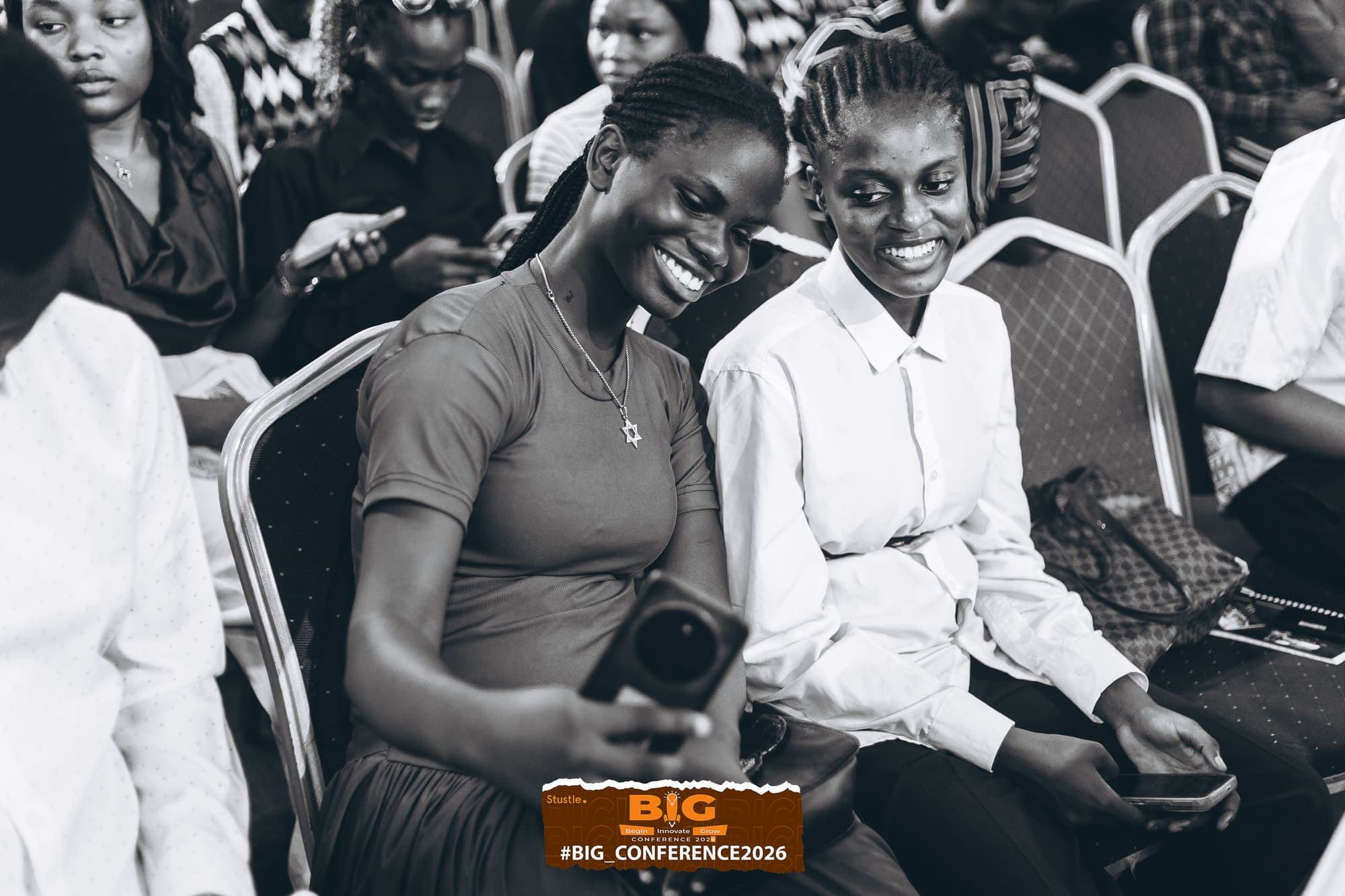 Two attendees smiling together in the audience